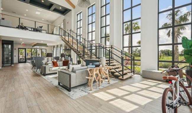 a clubroom with couches, stairs and a bike