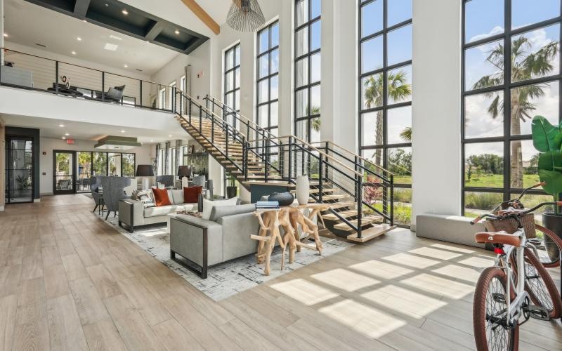 a clubroom with couches, stairs and a bike